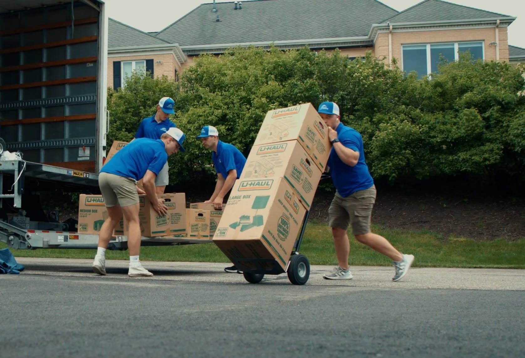 The Peak Movers crew loading packed boxes onto a hand truck during a move