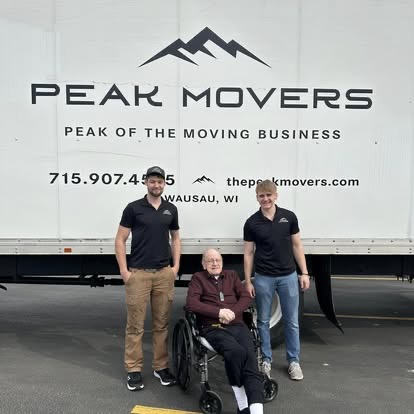 Peak Movers crew standing with a senior customer beside the moving truck